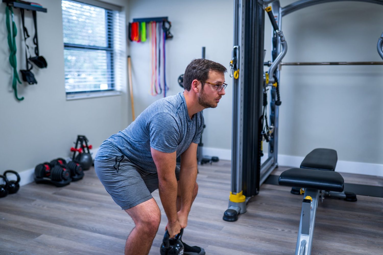 A patient hinging under a kettlebell during loaded rehabilitation.